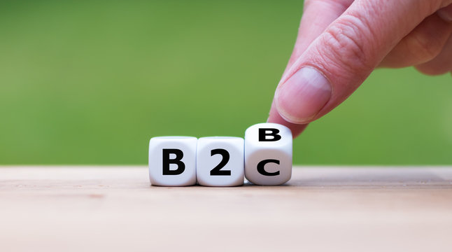 Business to Business or Busness to Consumer? Hand turns a dice and changes the expression "B2B" to "B2C" (or vice versa)