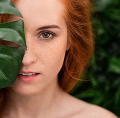 Portrait of young and beautiful woman in tropical leaves