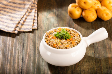 Lentil in ceramic bowl on rustic kitchen table background - Lens culinaris