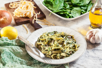 Tagliatelle pasta with spinach and mushrooms on a plate