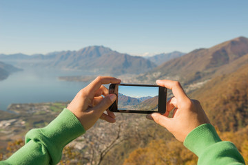 Woman Taking a Photo of the Mountain and Alpine Lake Maggiore with Mobile Phone in Ticino,...