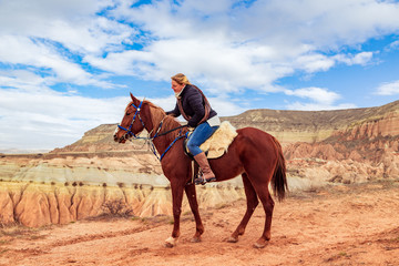 Girl riding a horse in the valley of Cappadocia.