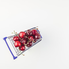 Ripe cherries in a shopping cart isolated