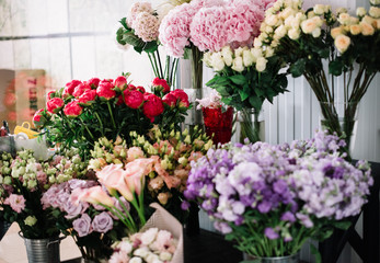 Fresh flowers at the florist shop: blossoming coral charm peonies, roses, carnations, mattiola and flower bouquets