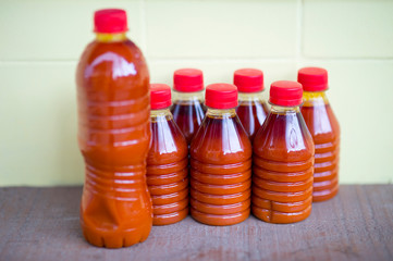 Collection of hand-produced bottles of fresh brown dendê palm oil, used in regional Afro-Brazilian cuisine on display in a village in Bahia, Brazil