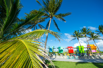 Scenic view of brightly painted colorful lifeguard towers under palm trees in South Beach, Miami