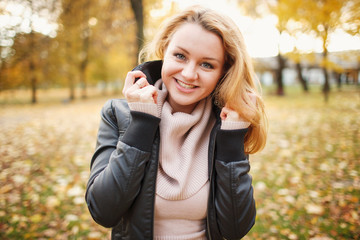 Beautiful girl walks and poses for photos in the autumn park with leaves