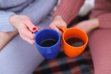 two bright mugs in the hands of girlfriends