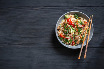 .Thai noodle wok with chopsticks on a black wooden background with a place for copy space