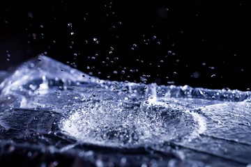 Water drops splashing on acoustic membrane. A lot of drops in air. High frequency of sound waves. Water cloud small drops. Frozen time shot.