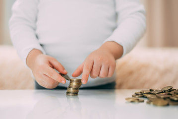 The child builds the tower of the coins closeup