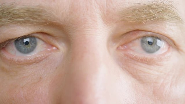 Close up eyes and face adult man. Senior man looking and winking front camera. Macro shooting male eyes. Ophthalmology and healthy vision. Health care. Parts of face and body. Human anatomy ECU detail