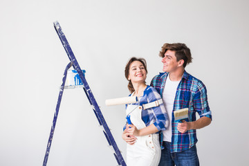 People, redecoration and repair concept - Lovely young couple doing renovation in new apartment
