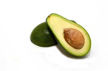 Two slices of fresh organic avocado isolated on a white background. One slice with core. Design element for product label, catalog print, web use. Tropical exotic food.