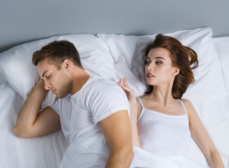 Unhappy young couple on the bed