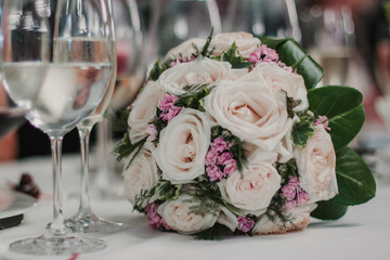 Ramo de novia sobre la mesa con rosas blancas