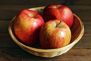 Three tasty red apples in basket