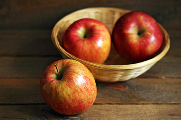 Three tasty red apples in basket