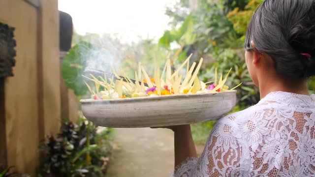 Woman Brings an Offering in a Hindu Temple. Traditional Balinese Spiritual Offering Process. 4K, Slowmotion.