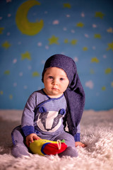 Little baby boy with cute teddy bear and moon on a blue star and moon background