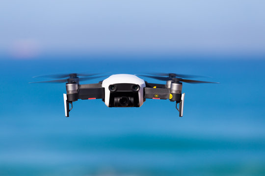 Electric drone flies in the sky above Mediterranean Sea, making wedding video, love story.