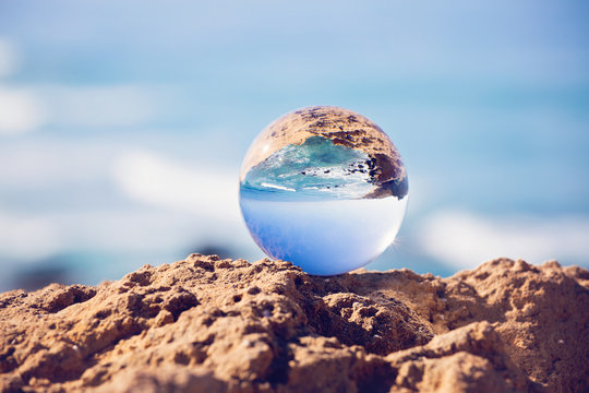 Sea reflection in the glass sphere, yoga relaxation, whole world in the ball