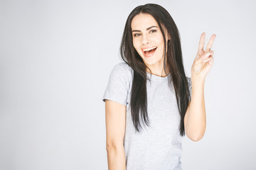 Positive funny woman in casual clothes shows ok sign, laughs at camera, demonstrates that...