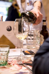 Sommelier pours wine into a glass of restaurant guests at dinner
