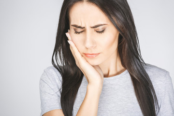 Young European woman isolated on white background suffering from severe toothache, feeling pain so...