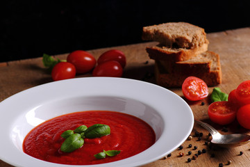 Tasty traditional tomato soup on wooden table