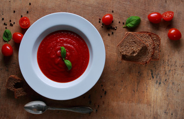 Plate with fresh tomato soup with basil