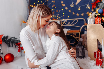 Happy family mother and little daughter playing in the winter for Christmas.