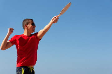 The guy plays matkot on the beach