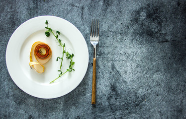 Tape for changing the body on a white plate on a dark background, the background is about losing weight, diet, losing weight