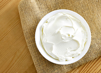 Cream cheese, quark or yogurt in a white bowl. Dairy product, healthy eating theme. wooden table background.