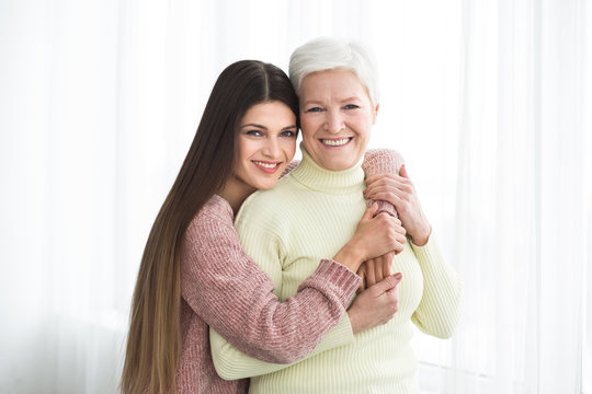 Happy Senior Mom And Daughter Hugging At Home