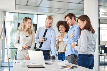 Small group of business people standing at office and solving problem at meeting. Multi cultural group.