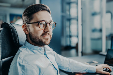 Obraz premium bearded trendy modern business man at work in office. manager with glasses.