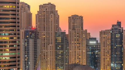 Dubai marina and JBR twers panorama day to night timelapse lights turn on.