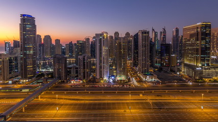 Fototapeta na wymiar Dubai marina with traffic on sheikh zayed road panorama day to night timelapse lights turn on.