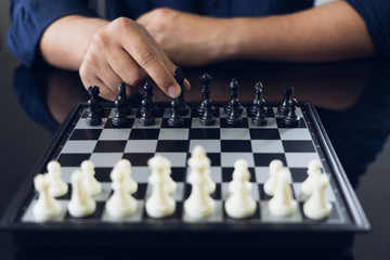 Businessman holding a King Chess is placed on a chessboard.using as background business concept and Strategy concept with copy space for your text or design.