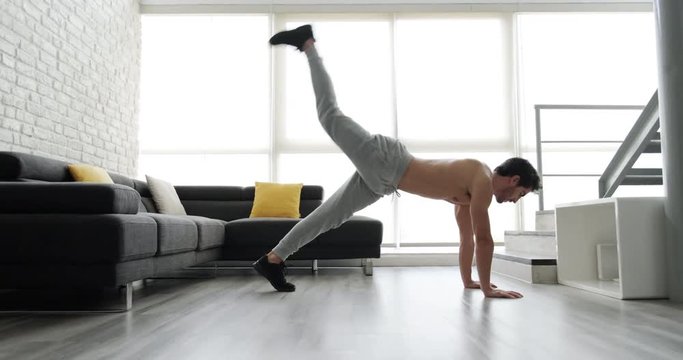Handsome young white man training at home. Beautiful hispanic male athlete training for wellness, leisure, fitness, healthy lifestyle in domestic gym. Latin people, sport activity. Plank with leg lift