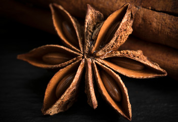 Star anise with cinnamon stick on a wooden table.