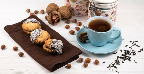 Cup of tea, stack of oatmeal cookies, tea maker on white wooden background Homemade bakery Healthy food snack concept