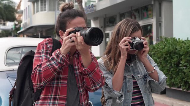 Photography students shooting outdoors in city with different cameras