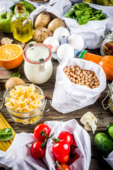 Zero waste shopping and sustanable lifestyle concept, various farm organic vegetables, grains, pasta, eggs and fruits in reusable packaging supermarket bags. copy space top view, banner