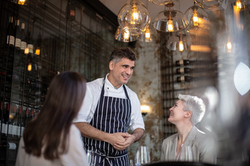 Chef greeting customers in his restaurant