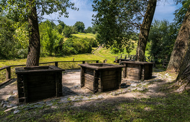 Fototapeta premium Three ancient wooden wells at the edge of the forest