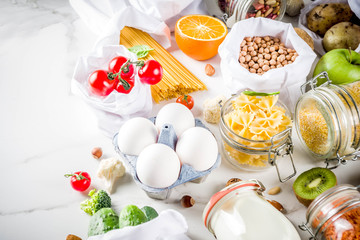 Zero waste shopping and sustanable lifestyle concept, various farm organic vegetables, grains, pasta, eggs and fruits in reusable packaging supermarket bags. copy space top view, banner