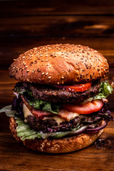 bbq hamburger on the stone table with cheese and serrano ham